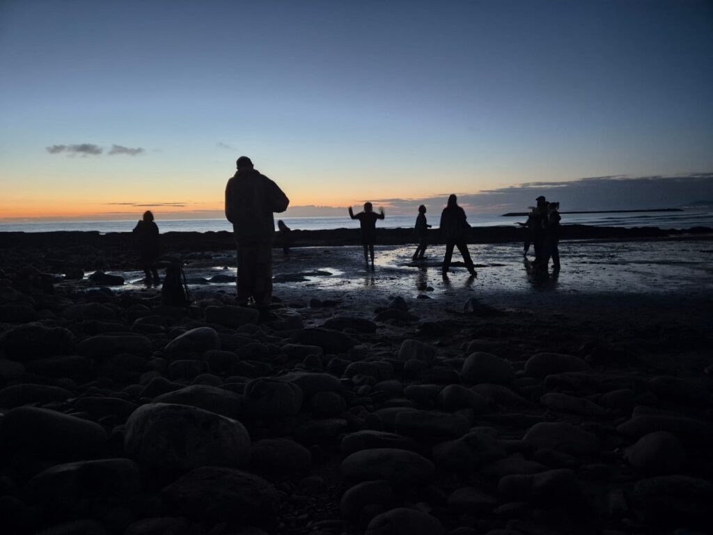 dancing people on a beach dusk 