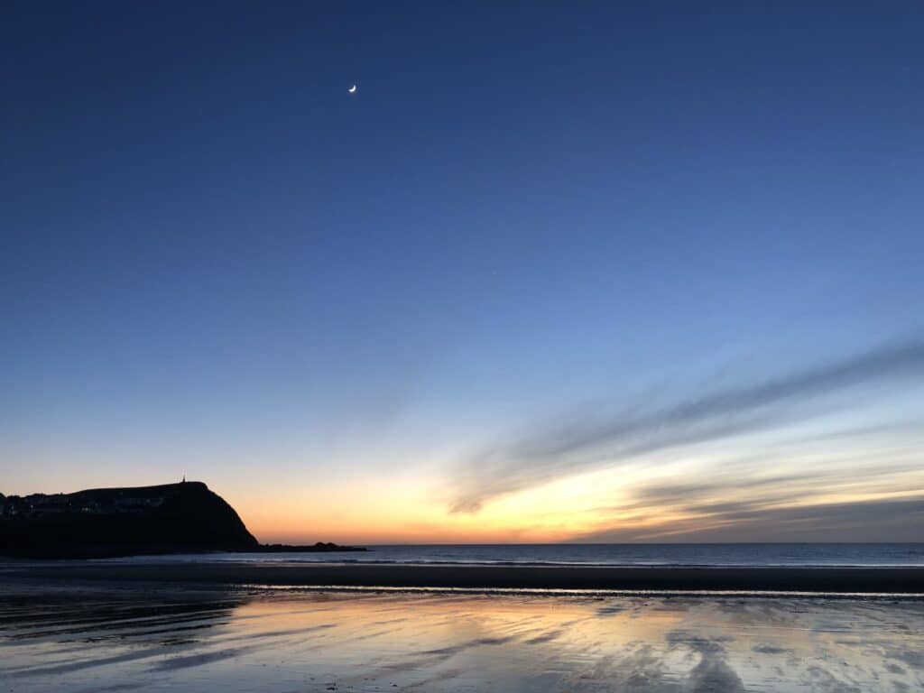 Serene beach at sunset with moon
